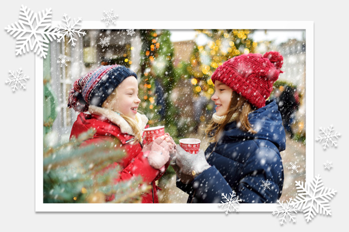 Kinder trinken Heißgetränke auf Weihnachtsmarkt
