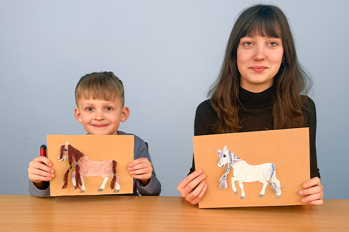 Pferdchen frisieren Zwei Kinder halten ihre frisierten Pferde und Einhörner