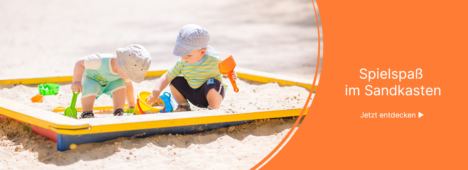 Zwei Kleinkinder spielen im Sandkasten