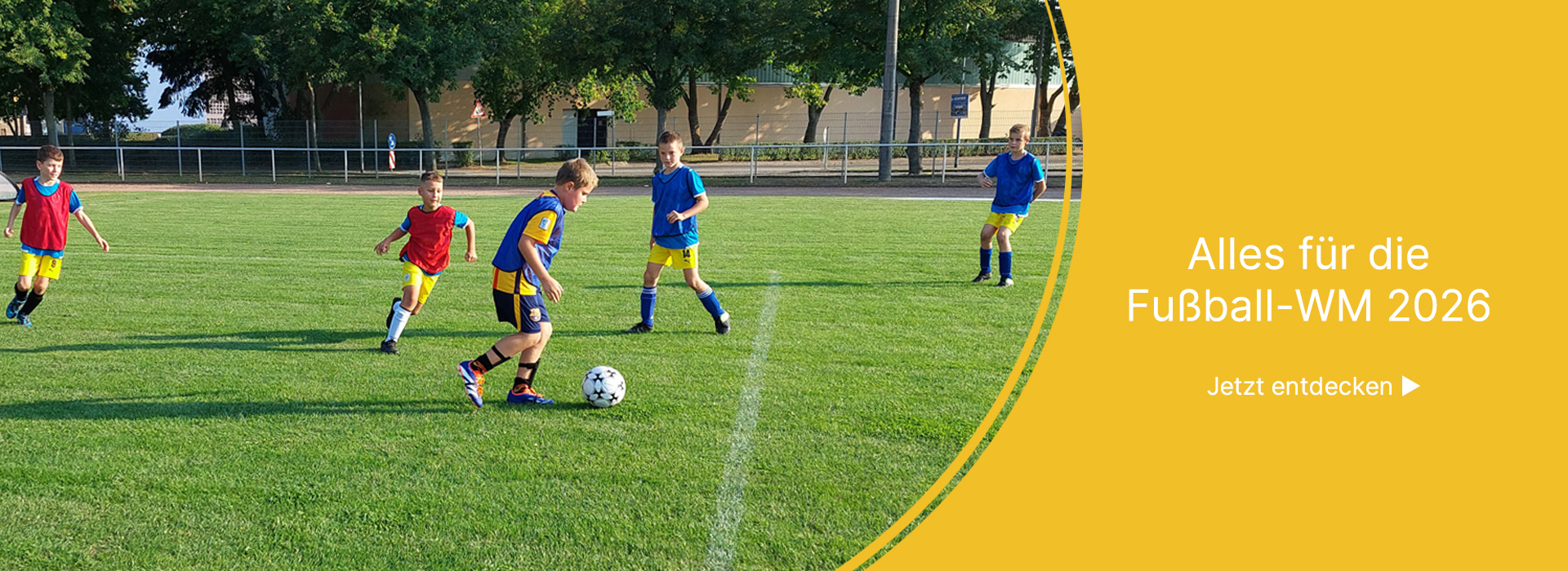 Kinder auf einem Sportplatz spielen Fussball