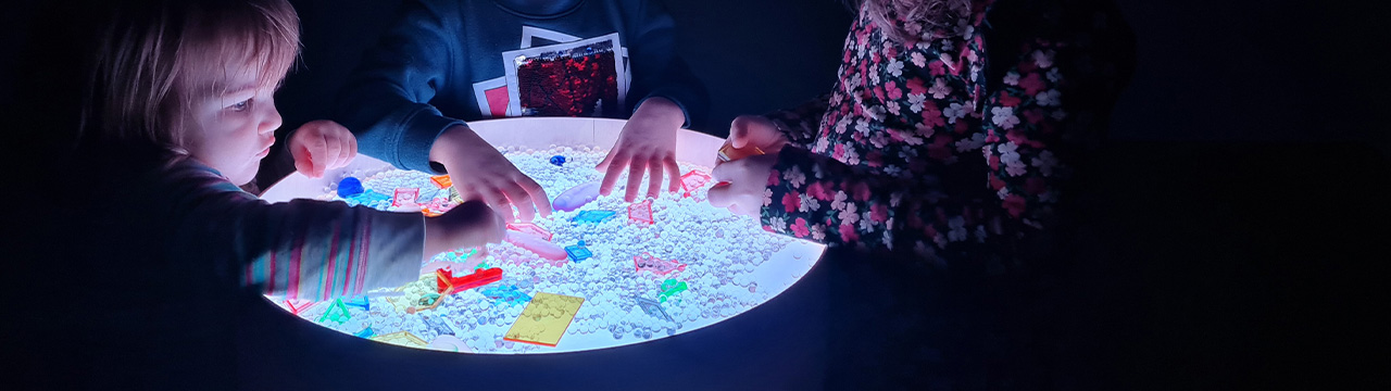 Spielen & Lernen Kinder spielen am Leuchttisch mit Sensorikspielzeug