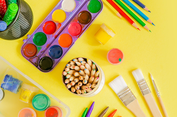 Banner für die Bastelwelt mit ganz viel Bastelmaterial auf gelben Grund