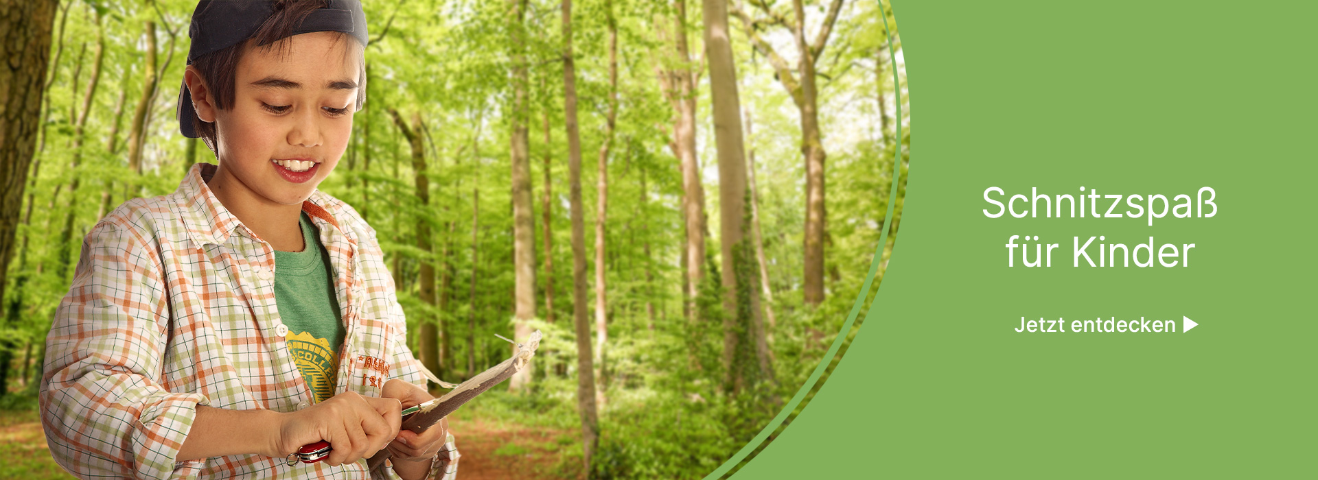 Junge steht im Wald uns schnitzt an einem Stock