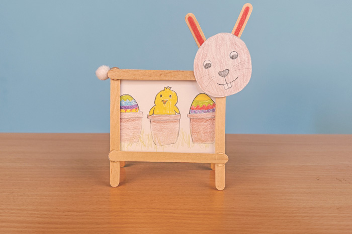 Bilder-Hase Hase aus Eisstäbchen präsentiert von Kind gemaltes Bild