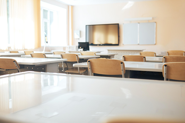 leerer Klassenraum mit Stühlen, Tischen, Fernseher und Whiteboard