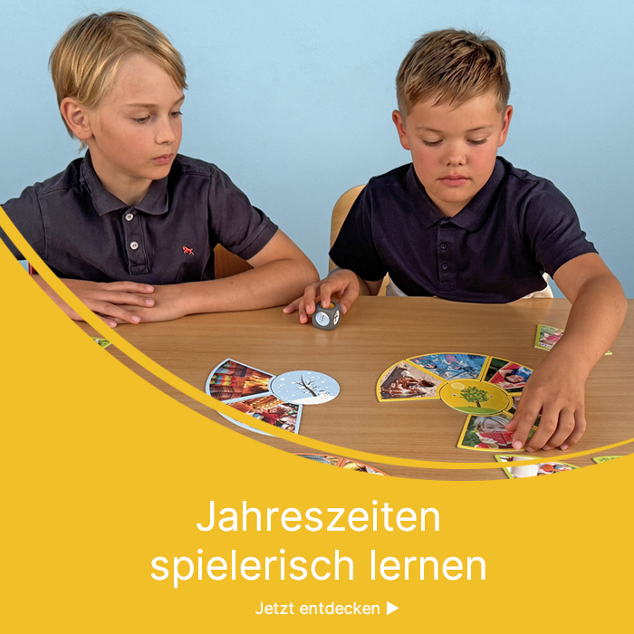 Zwei Jungen spielen ein Zuordnungsspiel auf dem Tisch zum Thema Jahreszeiten