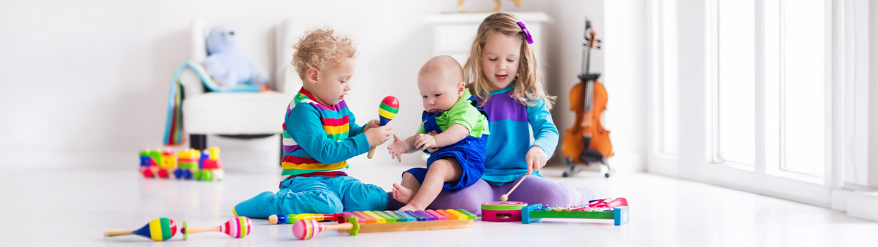 Musikalische Früherzeihung Drei Kleinkinder machen musikalische Früherzeihung in der Kita