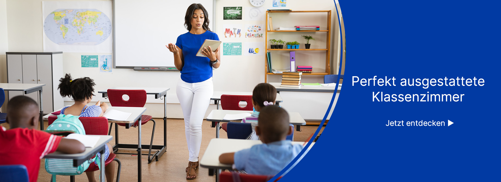 Lehrerin steht im Klassenzimmer vor den Schülern