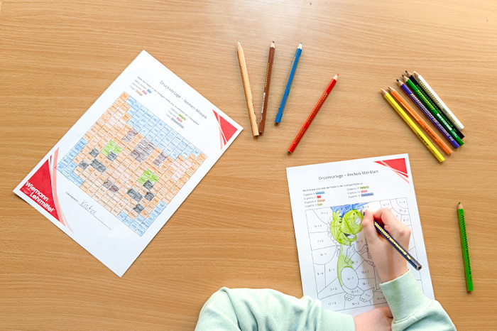 Grundschüler löst Aufgaben auf Arbeitsblättern