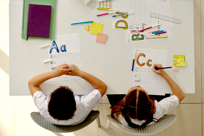 Zwei Schüler üben Buchstaben
