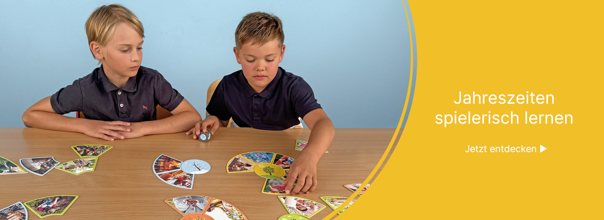 Zwei Jungen spielen ein Zuordnungsspiel auf dem Tisch zum Thema Jahreszeiten