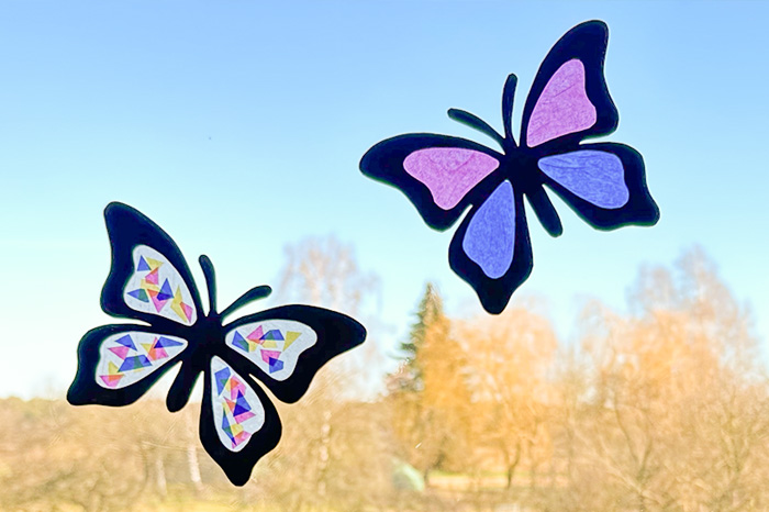 Bunte gebastelte Schmetterlinge am Fenster