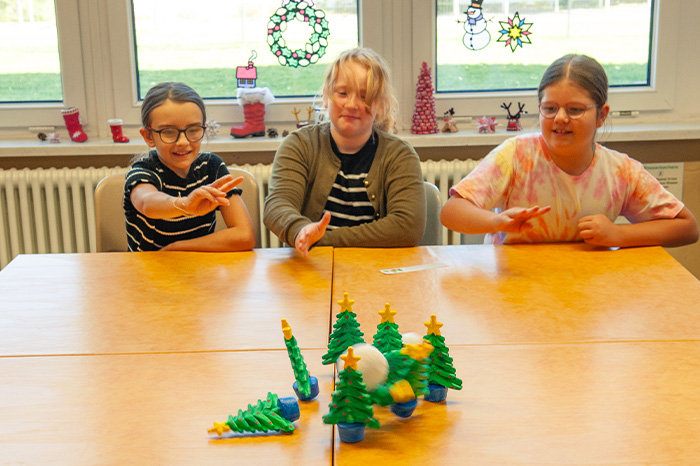 Weihnachtliche Bewegungsspiele Kinder kegeln Weihnachtsbäume mit Schneebällen