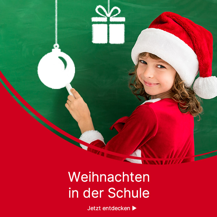 Kind mit Weihnachtsmütze malt mit Kreide Weihnachtssymbole an die Tafel