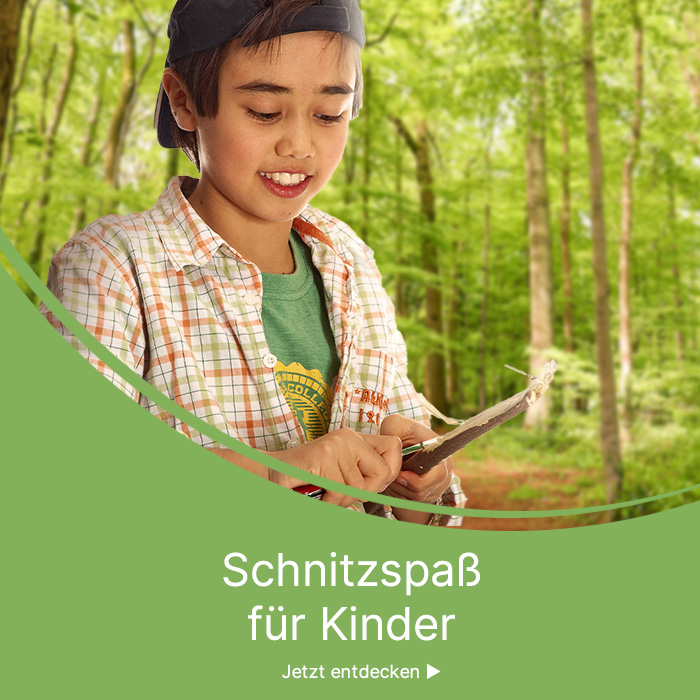 Kind schnitzt im Wald an einem Stock