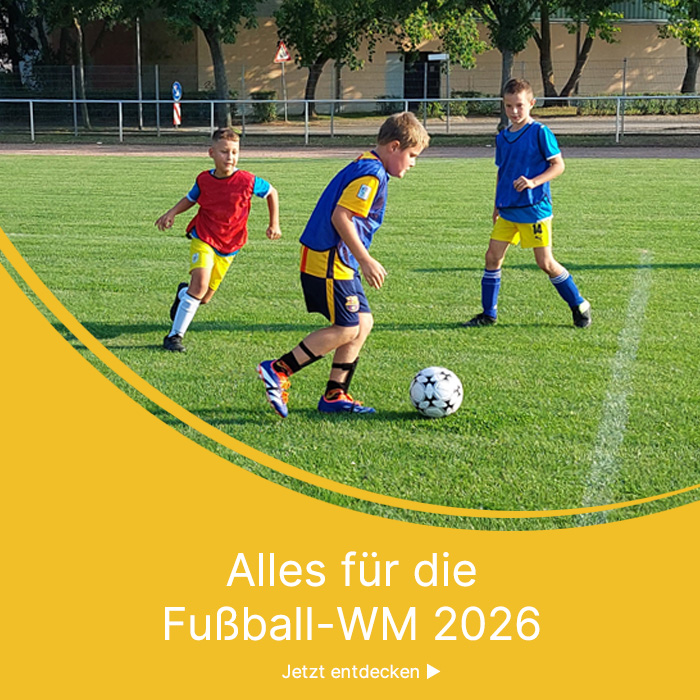 Kinder auf einem Sportplatz spielen Fussball